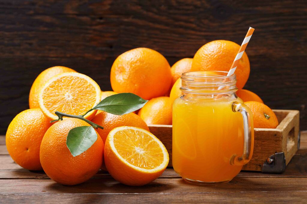 glass jar of fresh orange juice with fresh fruits on wooden table